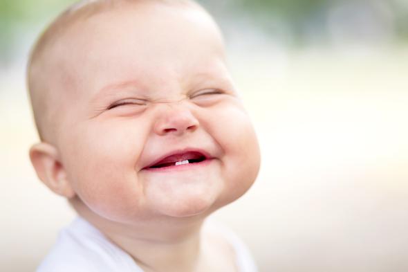 Freudiger Gesichtsausdruck - ein Baby freut sich doll über etwas.