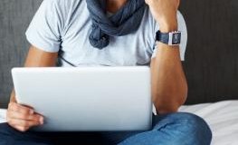 Ein Mann mittleren Alters sitzt nachdenklich vor seinem Laptop