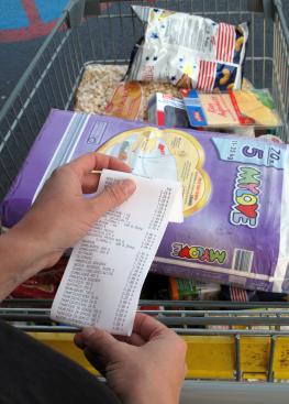 Kunde überprüft seinen Kassenzettel nach dem Einkauf im Supermarkt