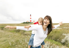 Friesland Varel: Mutter mit Kind, im Hintergrund ist ein Leuchtturm