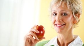 Eine Frau zeigt ihren Apfel