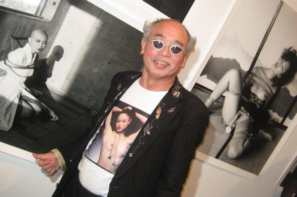 Nobuyoshi Araki posiert vor seinen erotischen Bildern.